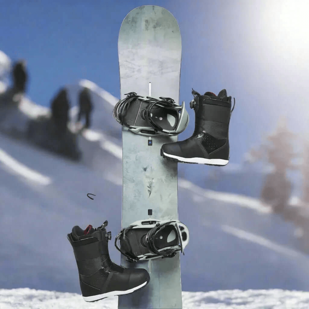 Tabla de snowboard gris con fijaciones y dos botas de snowboard negras