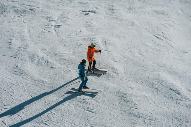 Maestro di sci che spiega la tecnica a un allievo su una pista di Baqueira