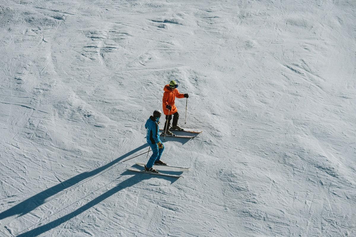 Maestro di sci che spiega la tecnica a un allievo su una pista di Baqueira