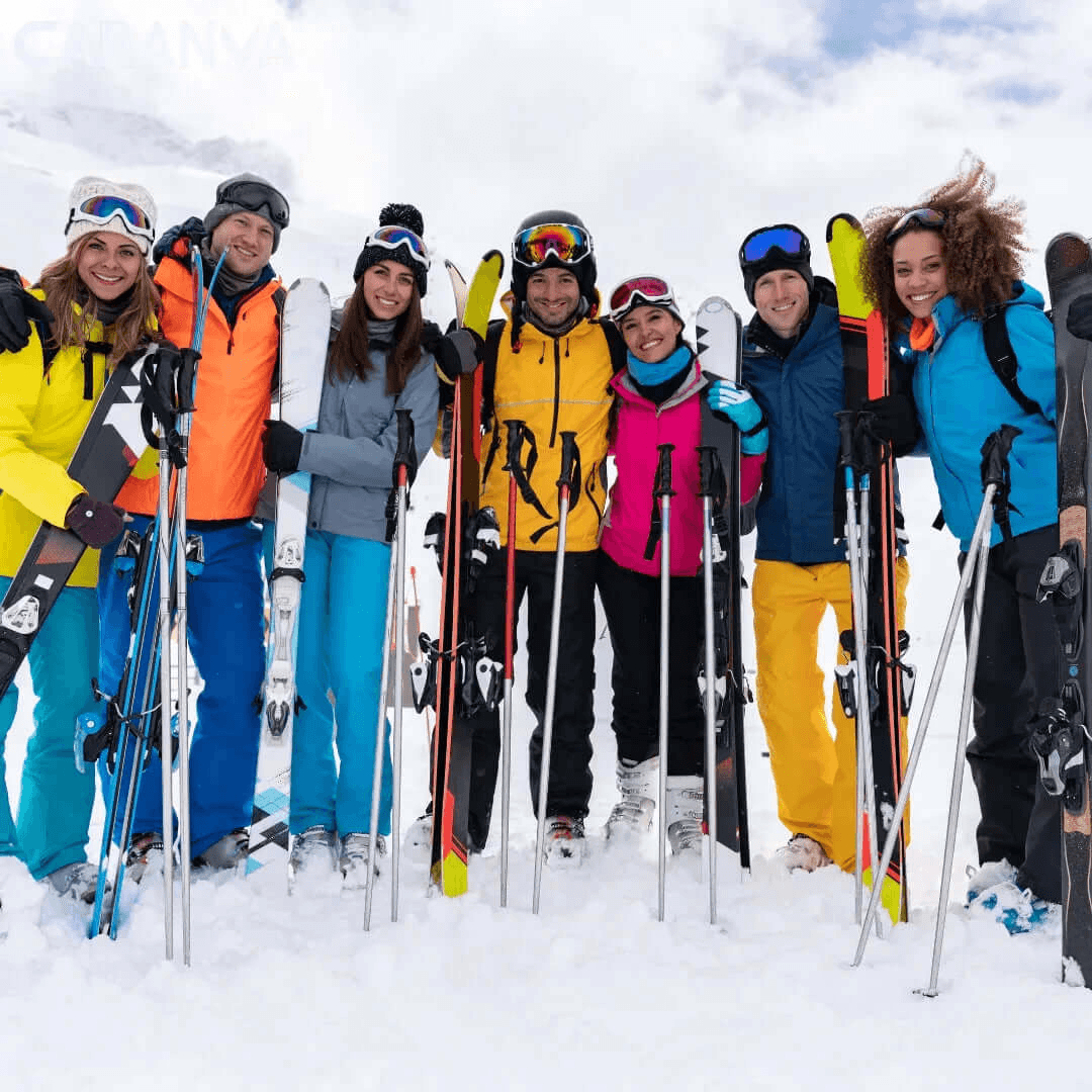 Gruppo di amici sorridenti sulla neve con sci e bastoncini