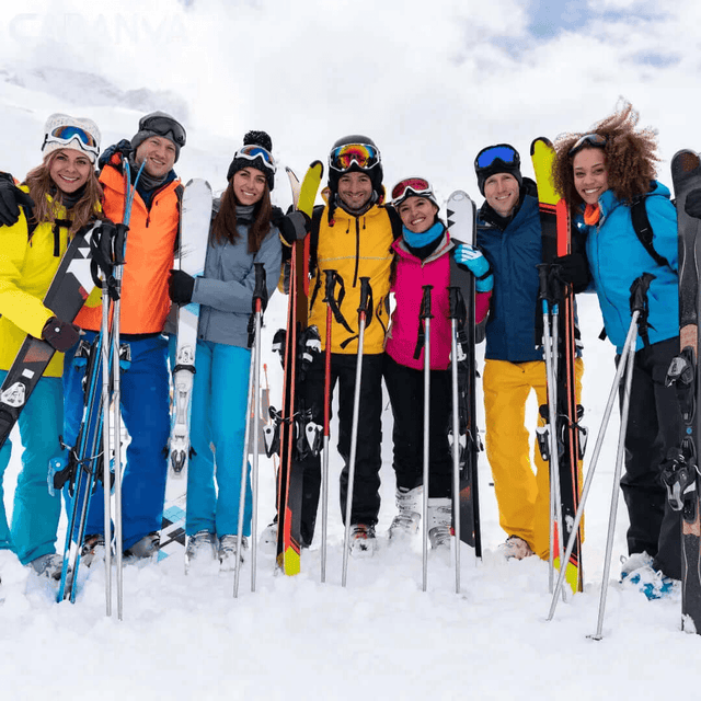 Gruppo di amici sorridenti sulla neve con sci e bastoncini